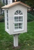 Free library with windows and self-closing door.